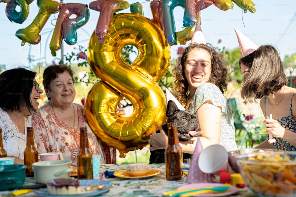 a group of women standing around a table with balloons
