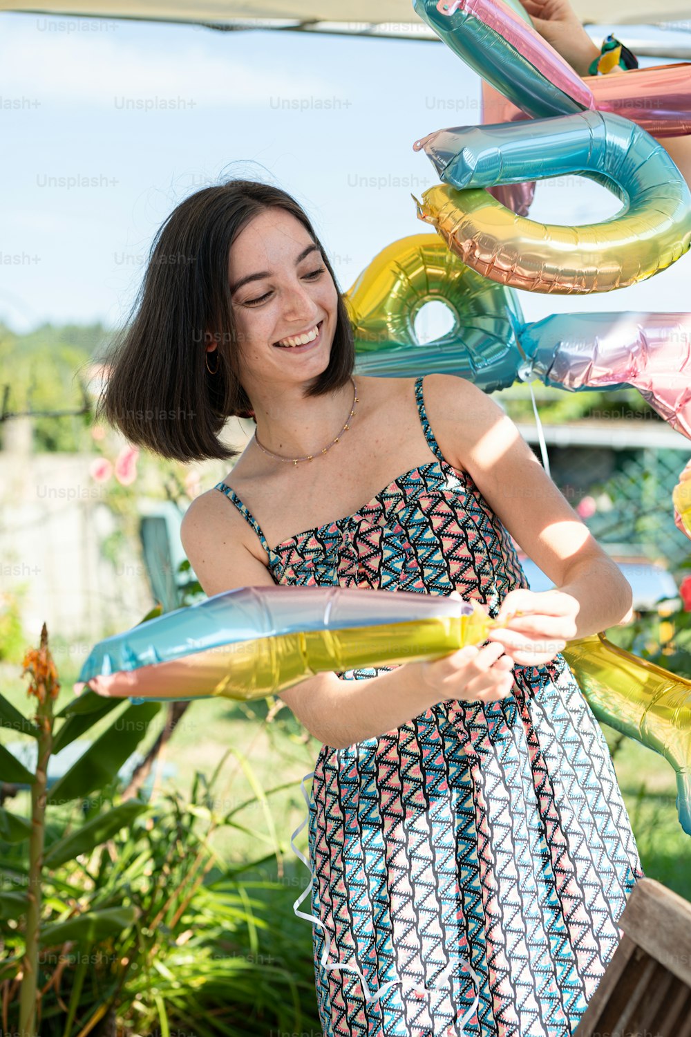 a woman holding a bunch of balloons in her hands