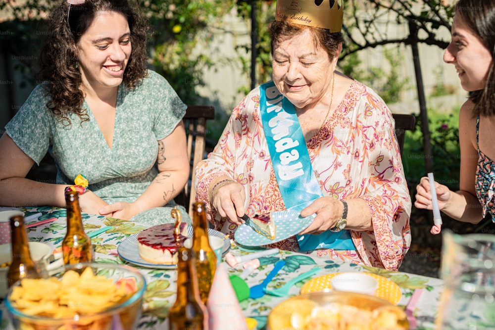 음식 접시가 있는 식탁에 앉아 있는 세 명의 여성