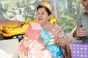 a woman in a birthday hat holding a blue bag