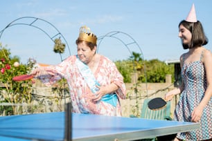 a woman in a party hat is playing ping pong