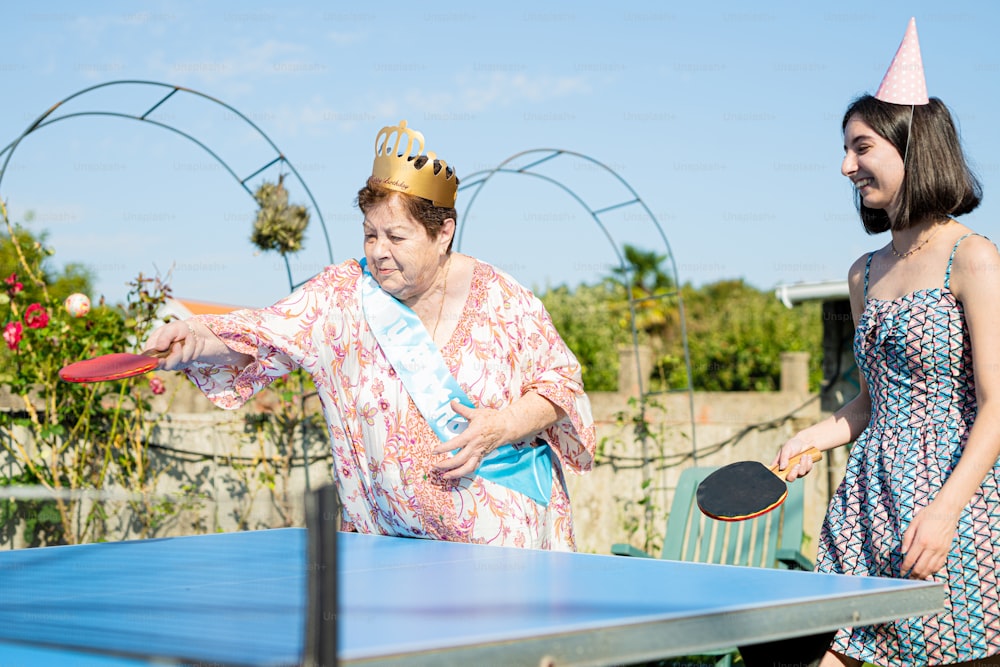 Una mujer con un sombrero de fiesta está jugando ping pong
