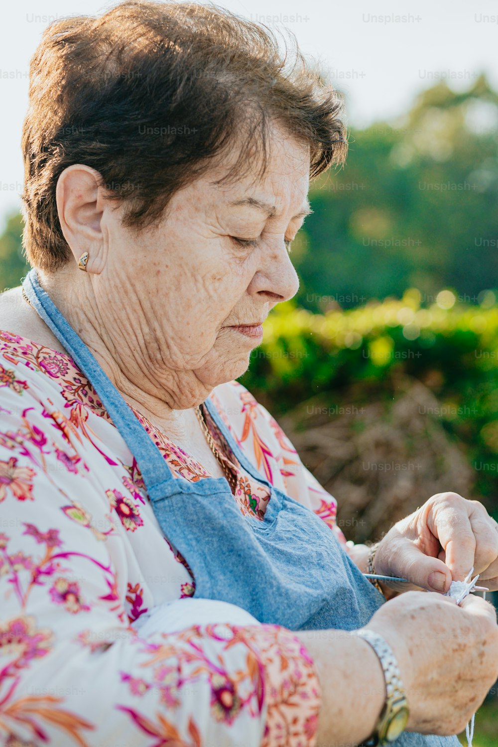 Una donna anziana che tiene un paio di forbici tra le mani