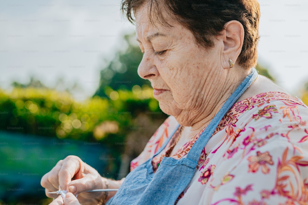 an older woman holding a pair of scissors in her hands