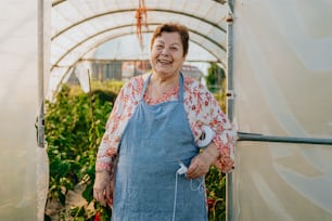 a woman in a blue apron standing in a greenhouse