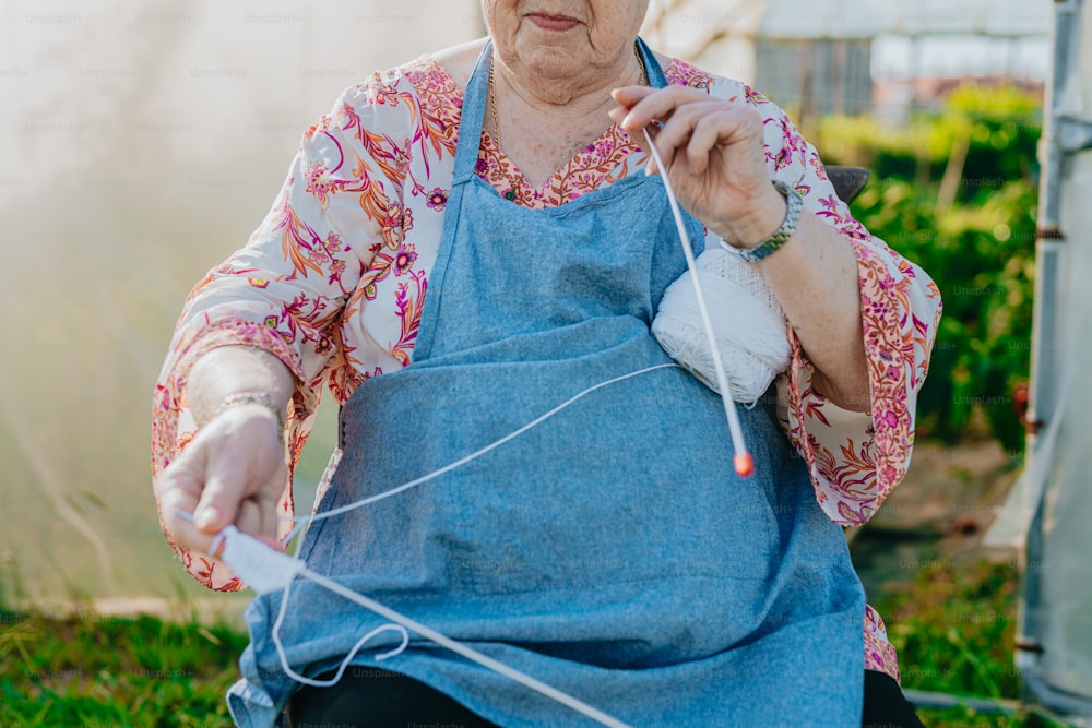 an elderly woman knitting a piece of cloth