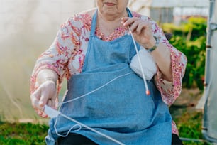 an elderly woman knitting a piece of cloth