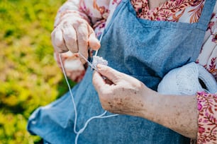 uma mulher está tricotando um pedaço de tecido com uma tesoura