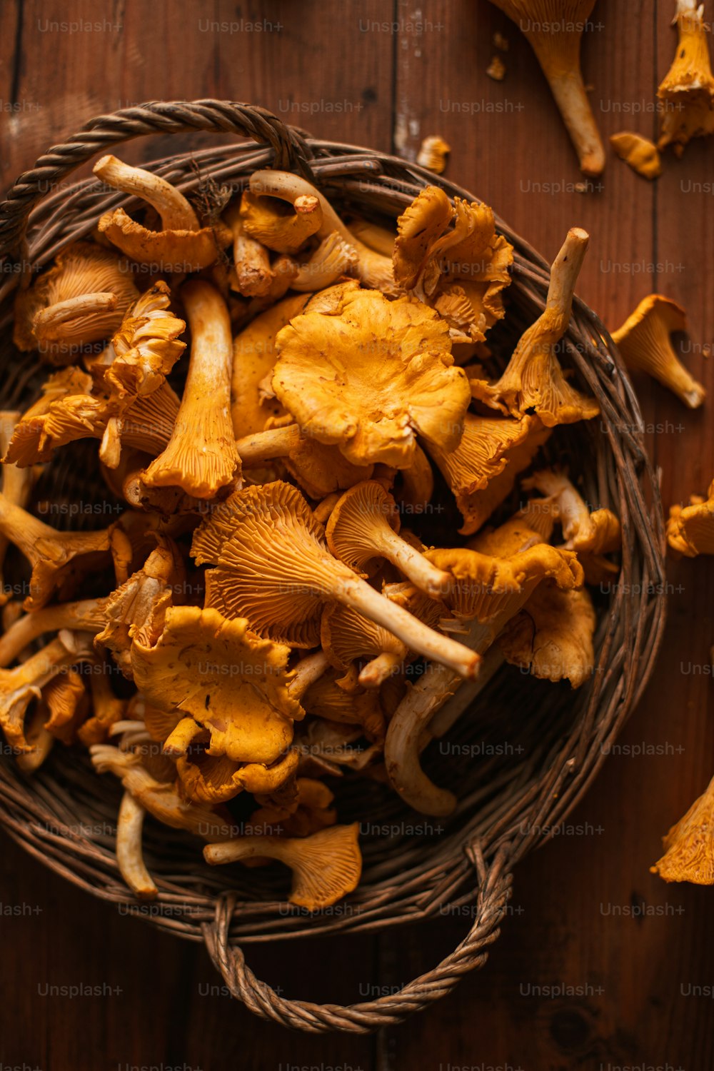 a basket filled with yellow mushrooms on top of a wooden table