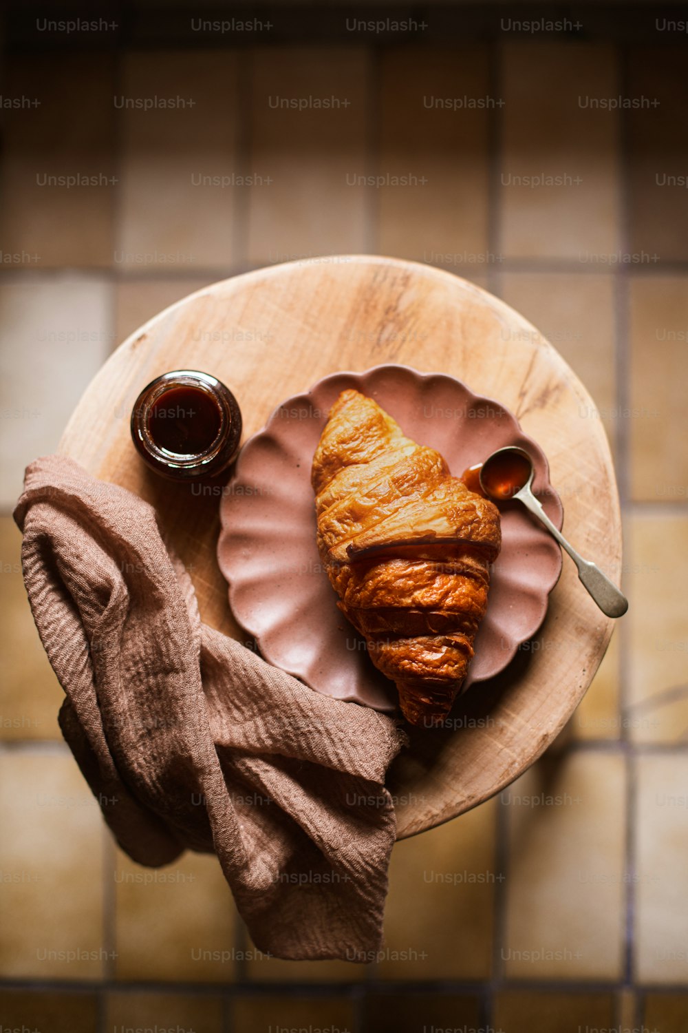 a plate with a croissant and a cup of coffee on it