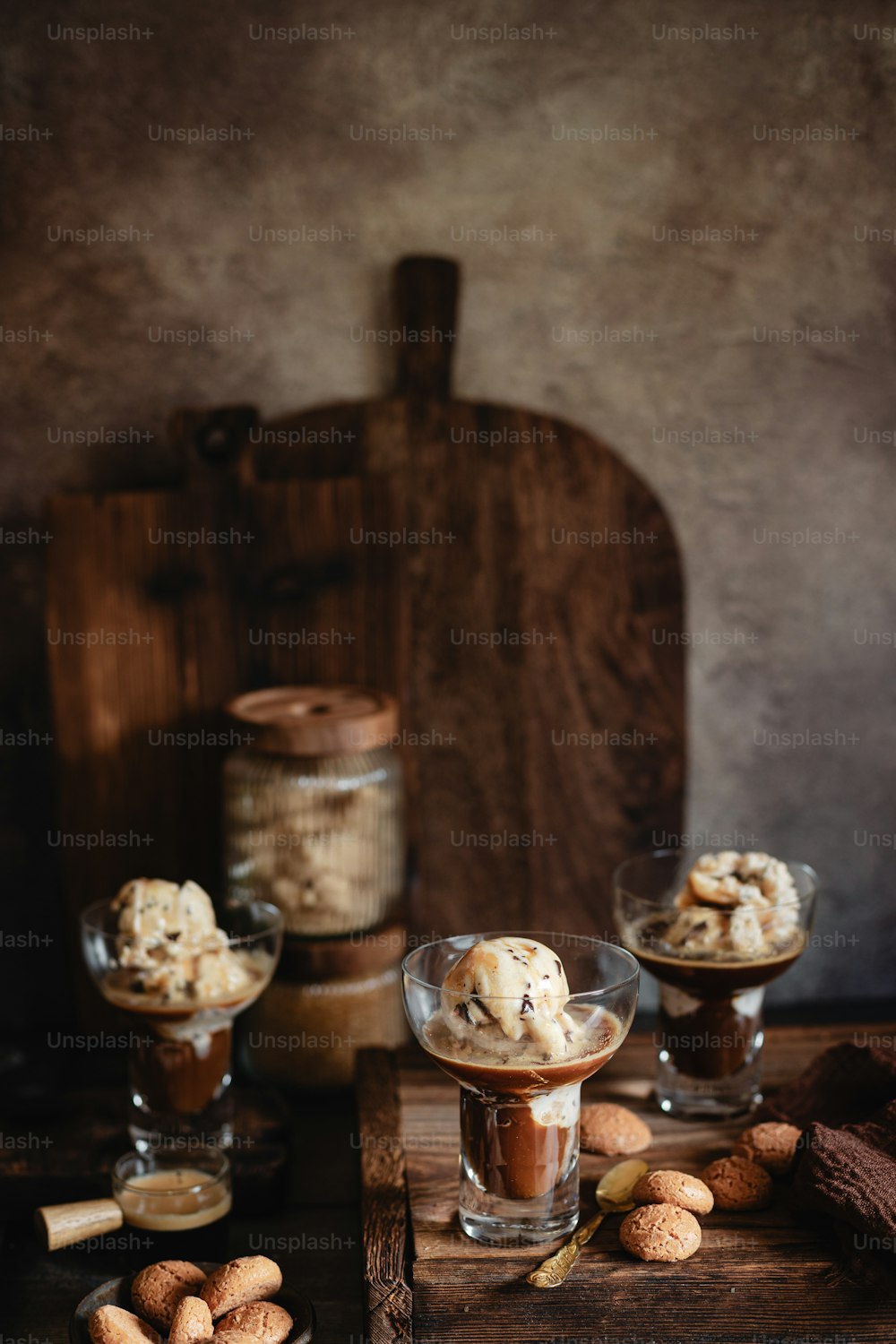 a wooden table topped with two glasses filled with ice cream