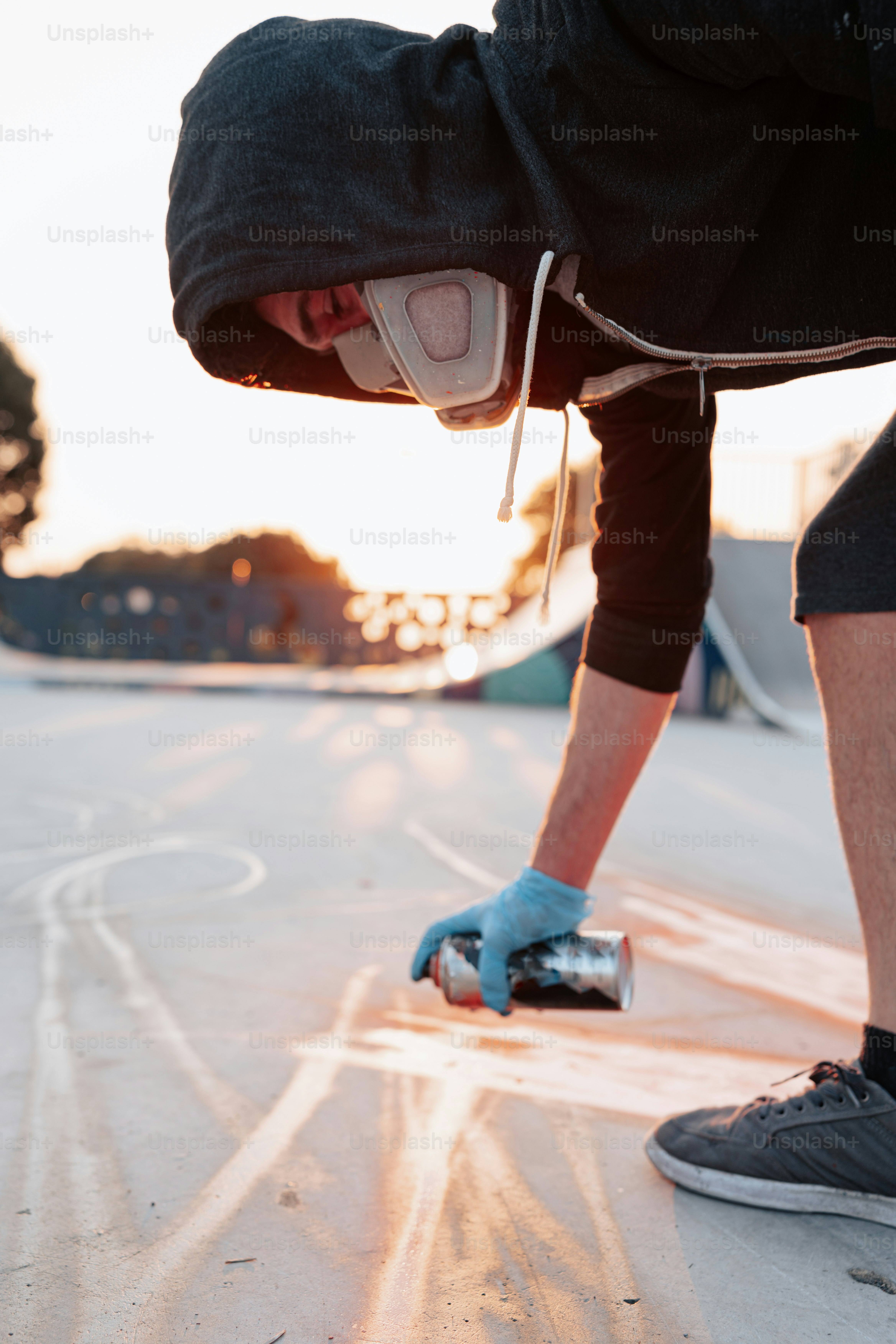 a skateboarder in a black jacket and blue gloves