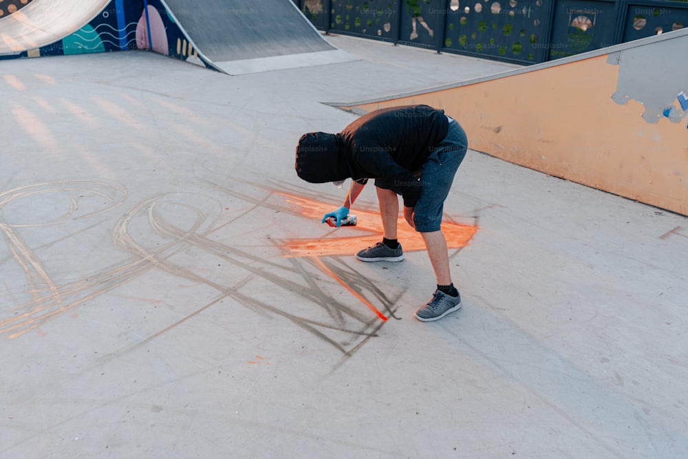 a man bending over on a skateboard at a skate park