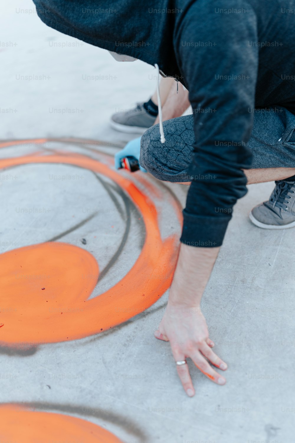 a person is painting a circle with orange paint