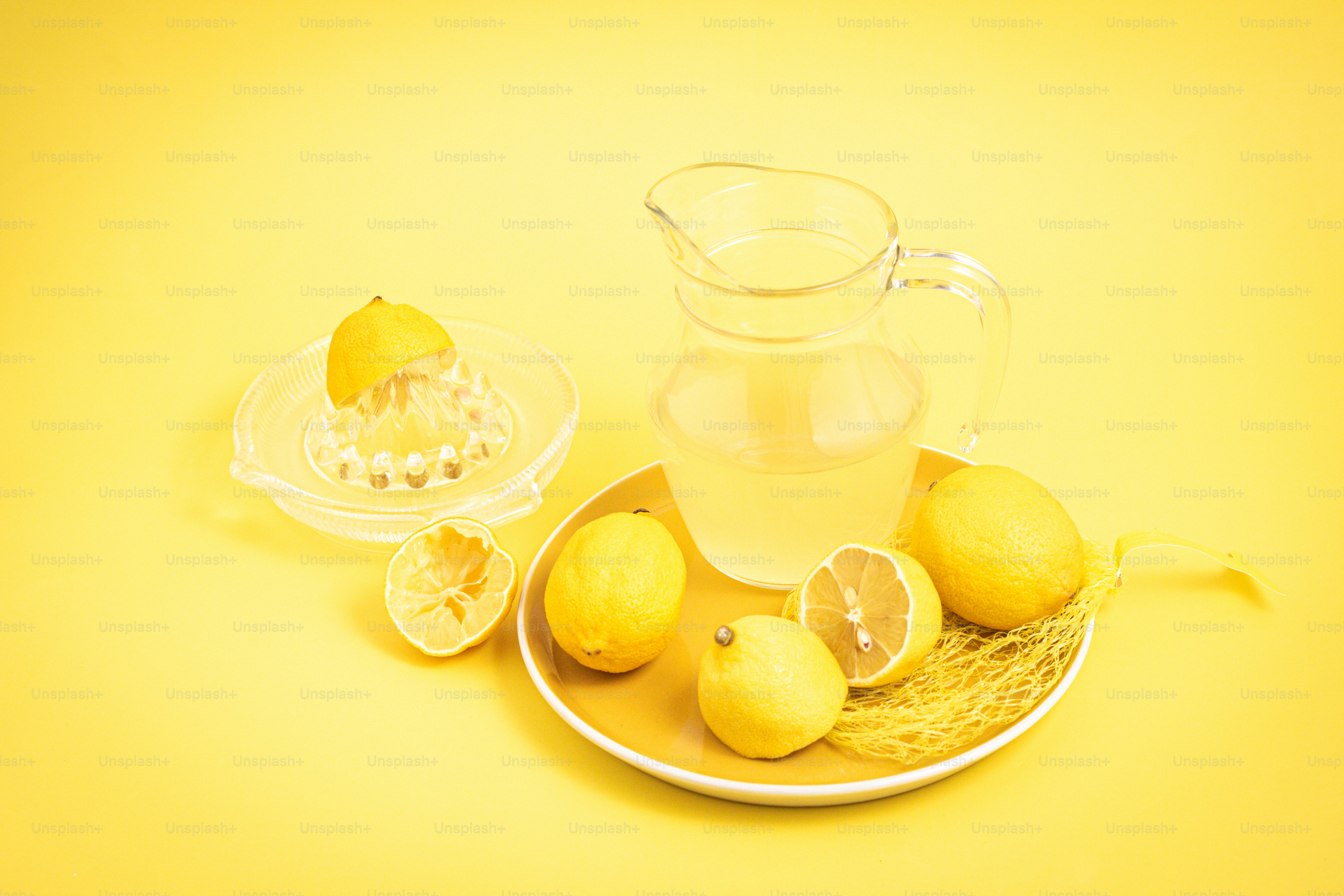 a plate with lemons and a pitcher of water