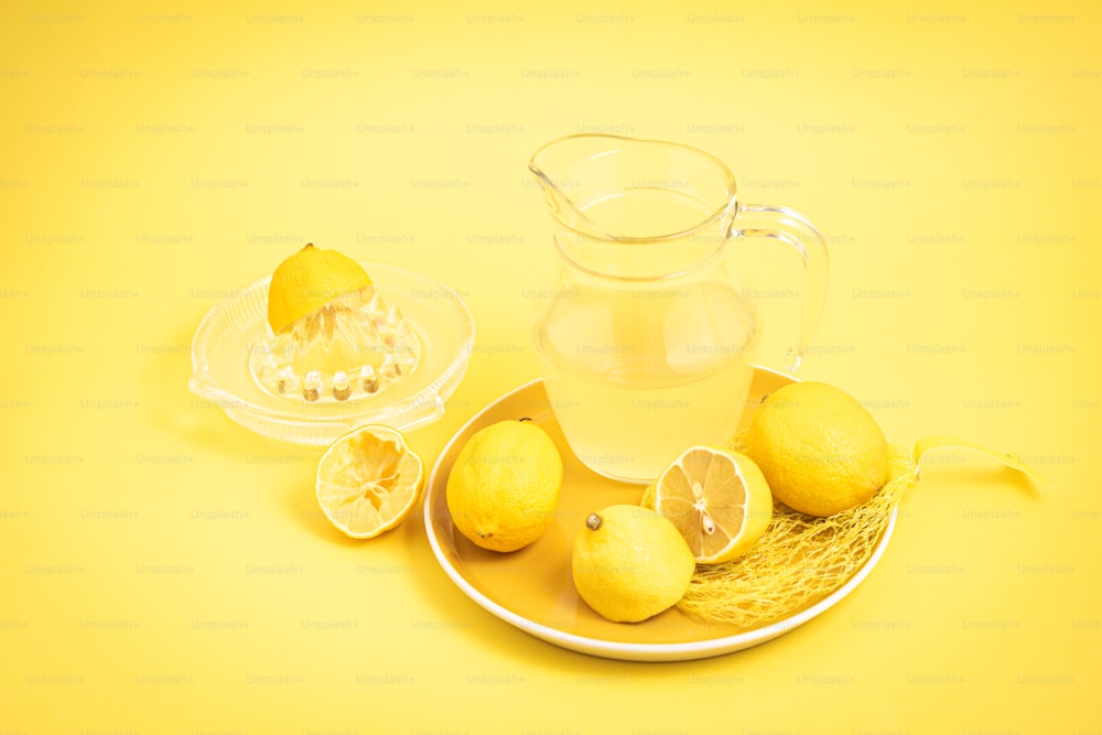 a plate with lemons and a pitcher of water