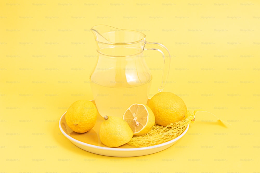접시에 물 한 주전자와 레몬 몇 개