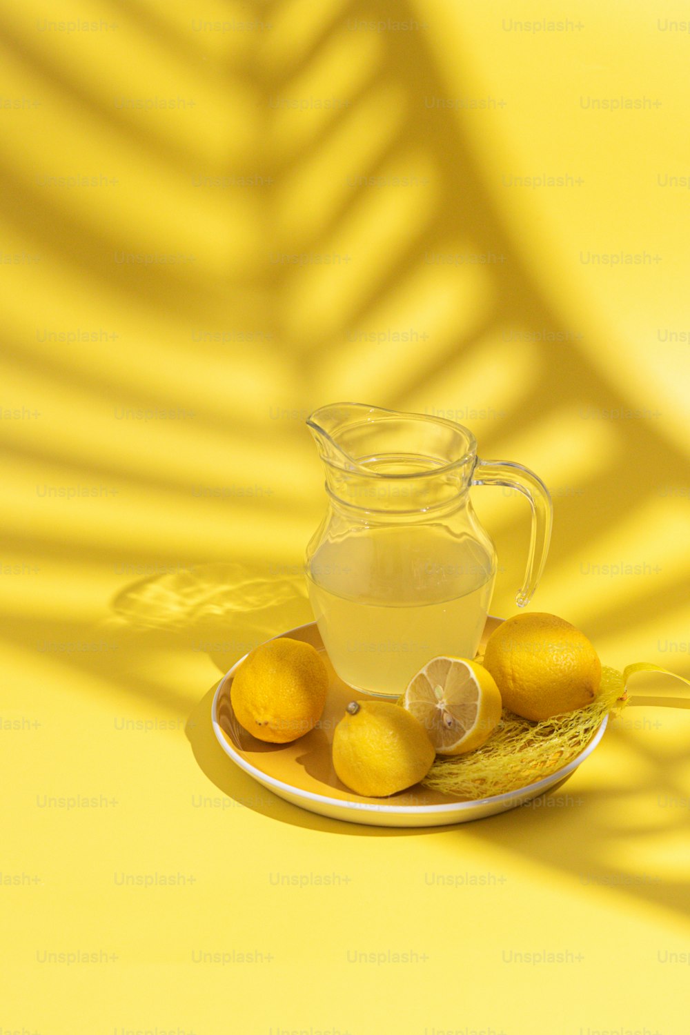 una brocca di limonata seduta sopra un piatto