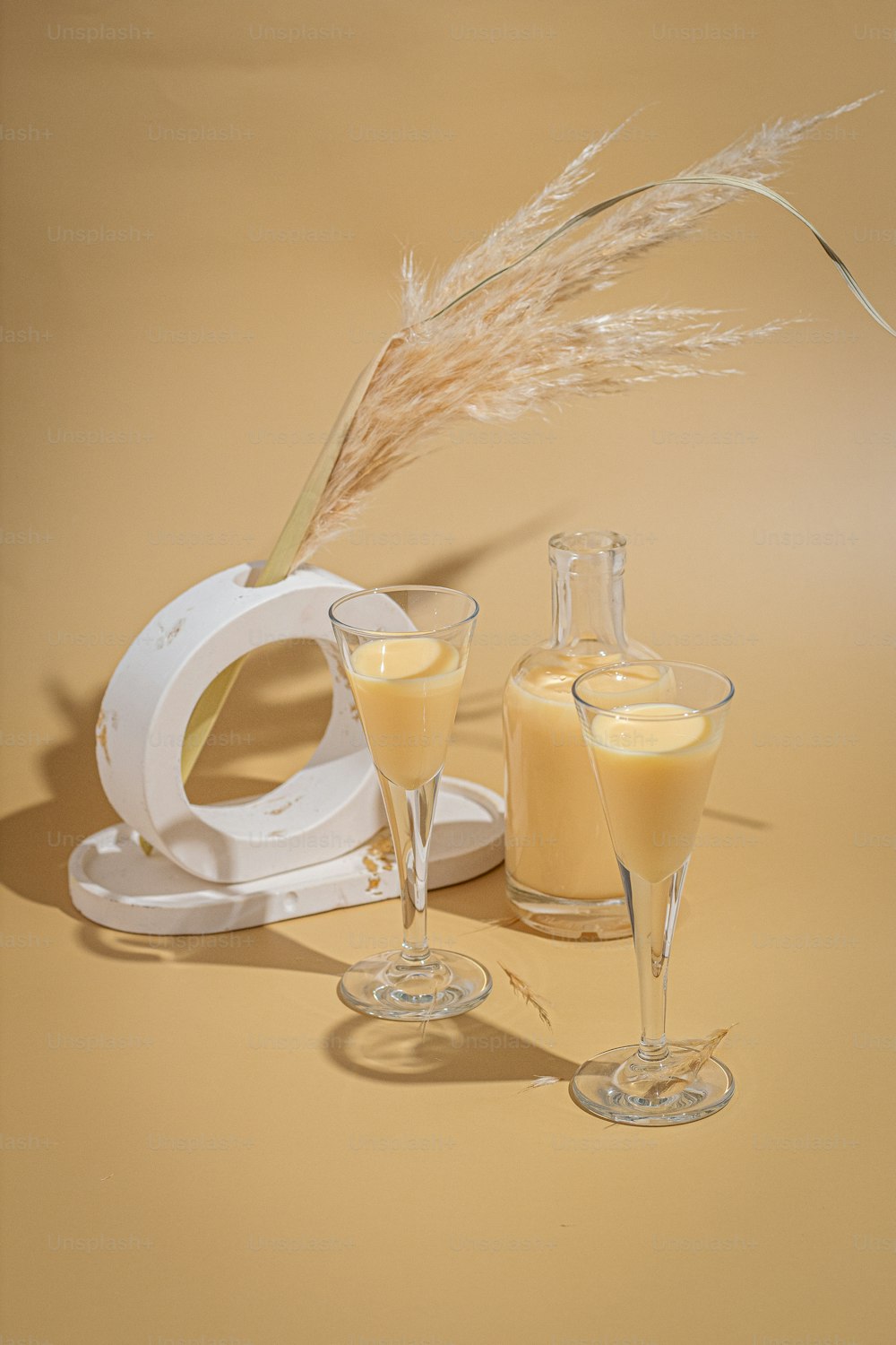 a glass of orange juice next to two glasses of orange juice