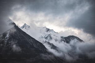 Una montagna coperta di nuvole sotto un cielo nuvoloso