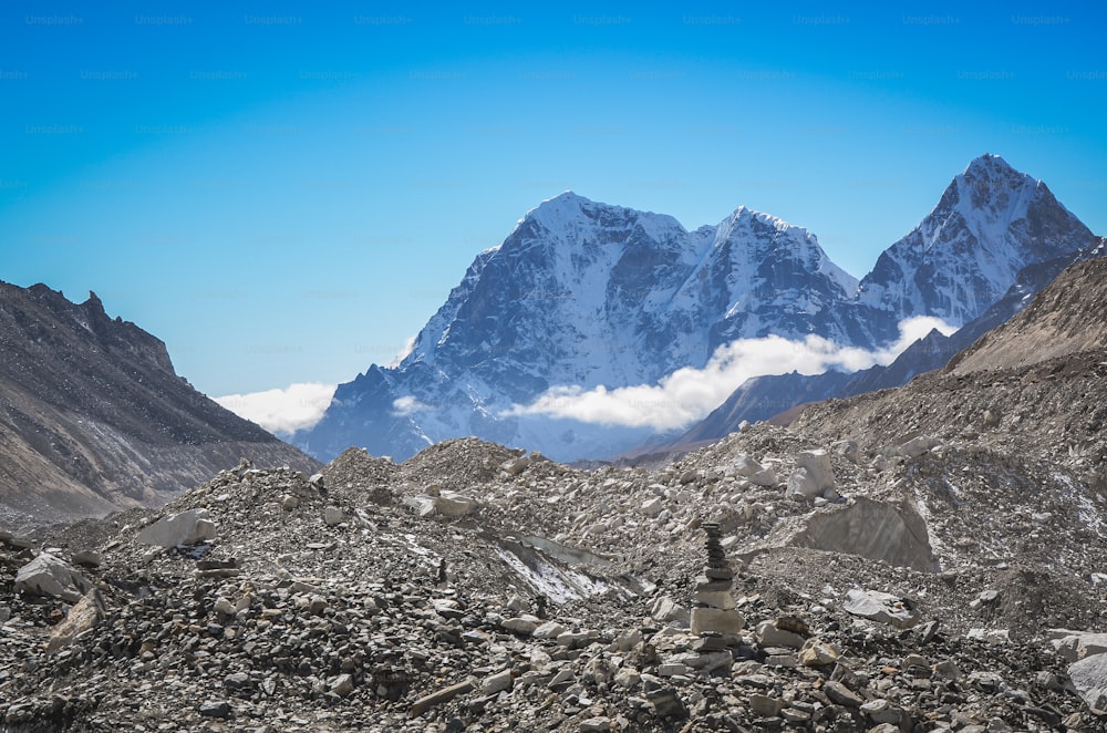 a mountain range with a pile of rocks in the foreground