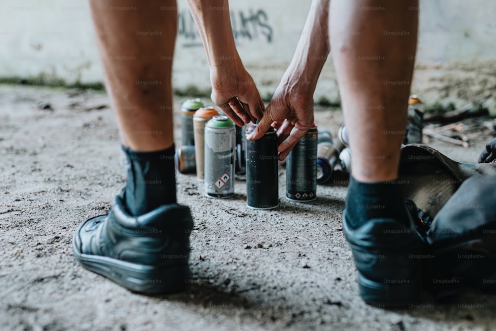 a person standing over a couple of cans