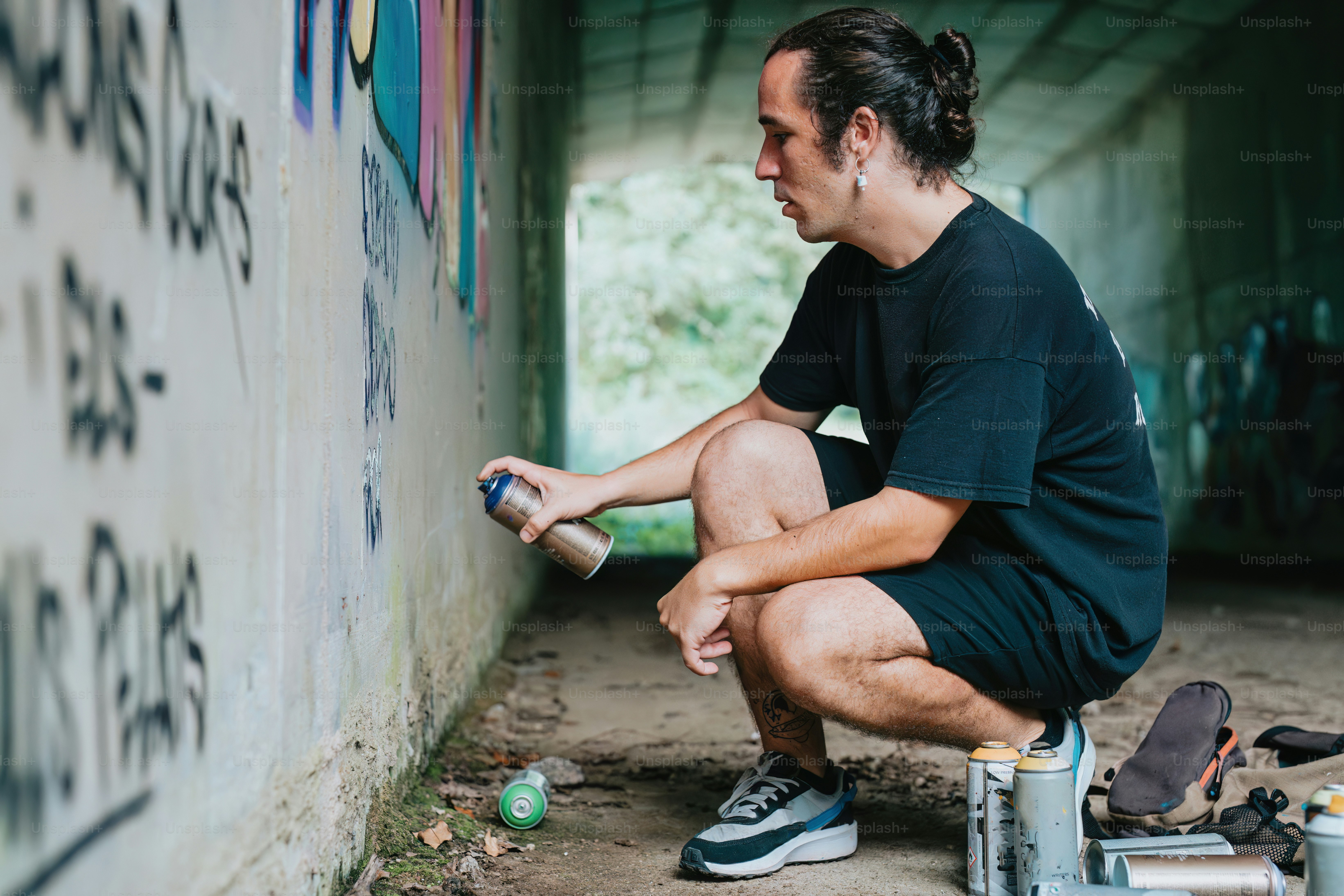 a man sitting on the ground painting a wall
