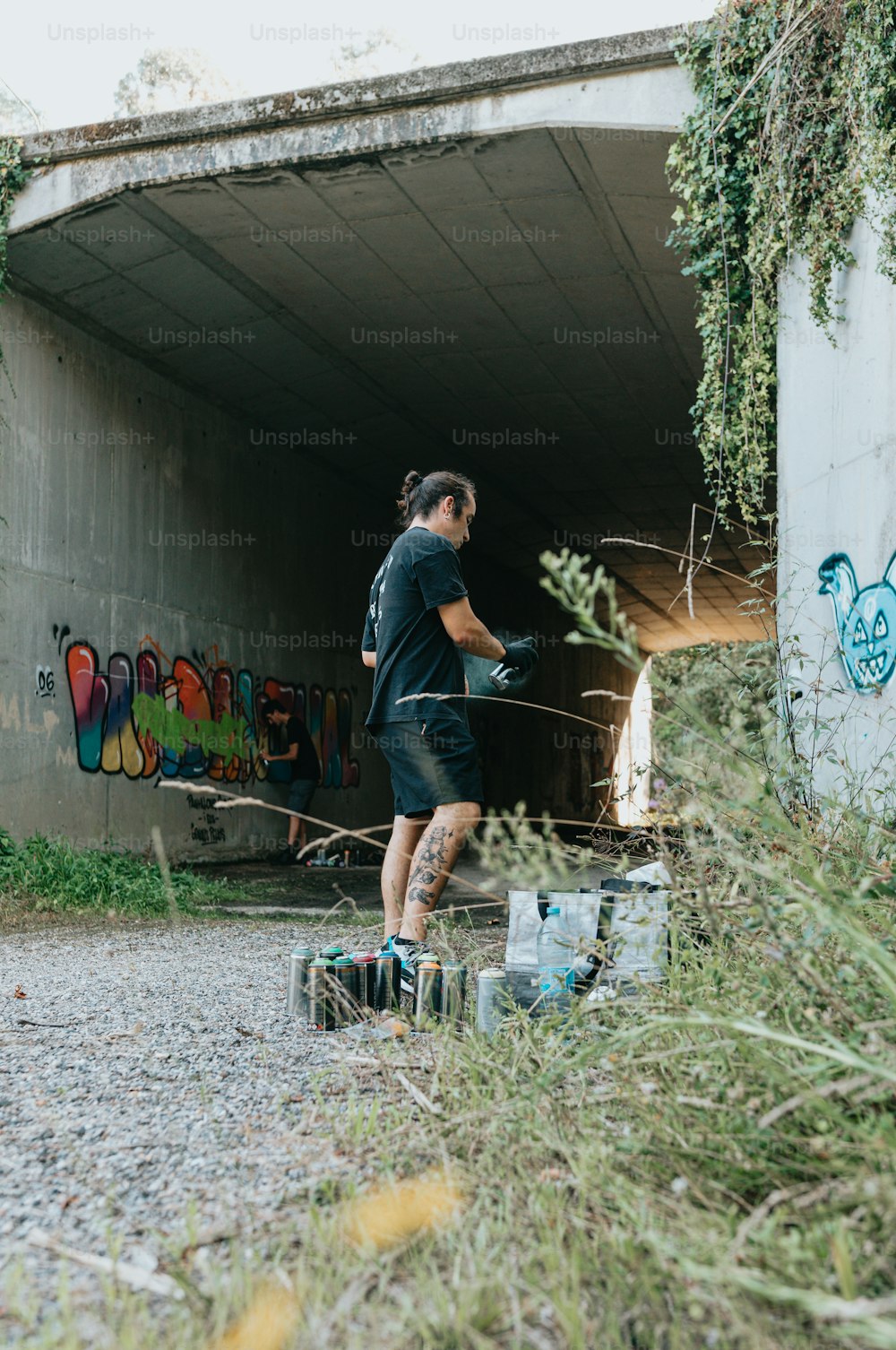 a man standing in front of a graffiti covered wall