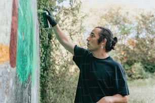 男が緑のペンキで壁を塗っている