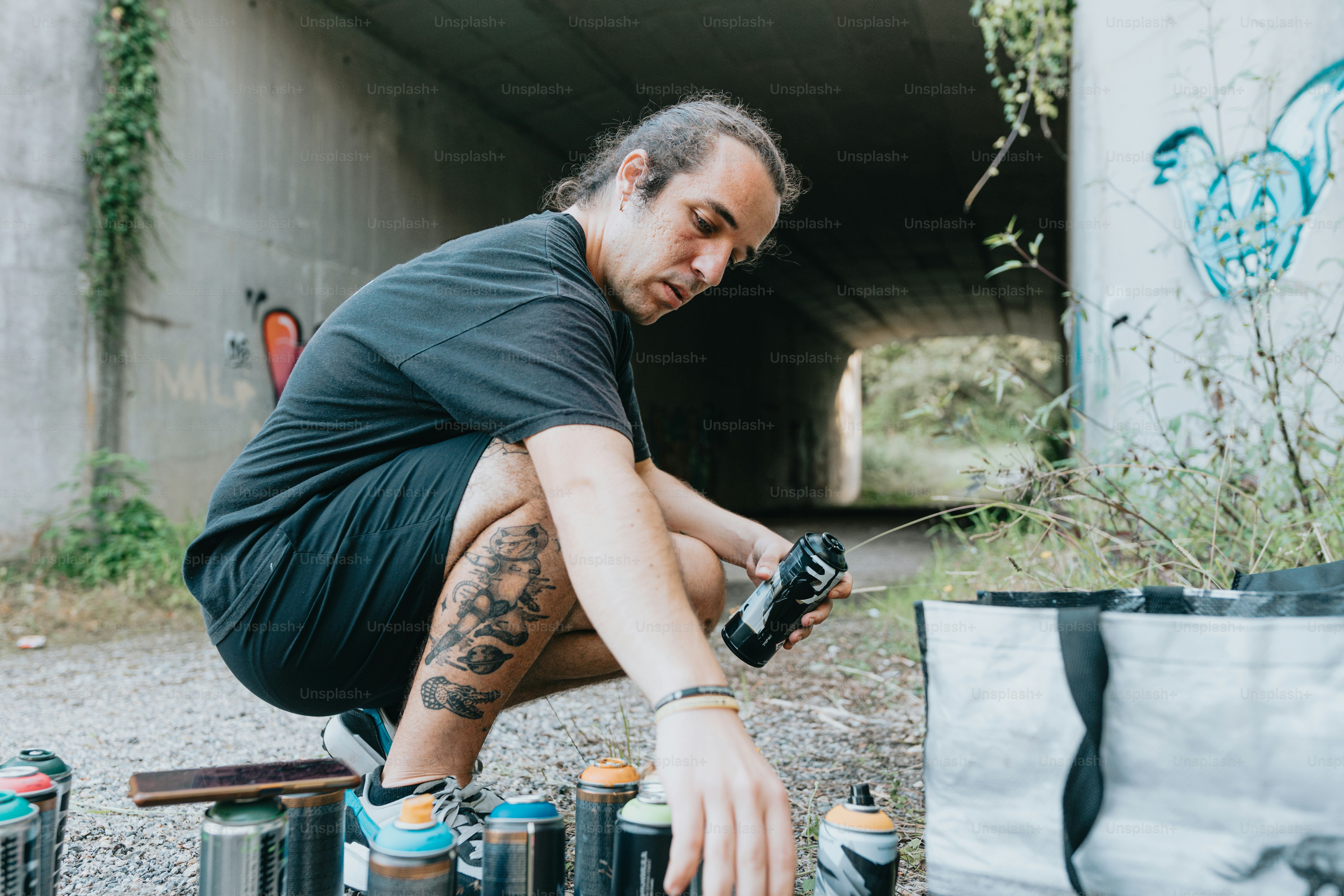 a man kneeling down next to a bunch of cans
