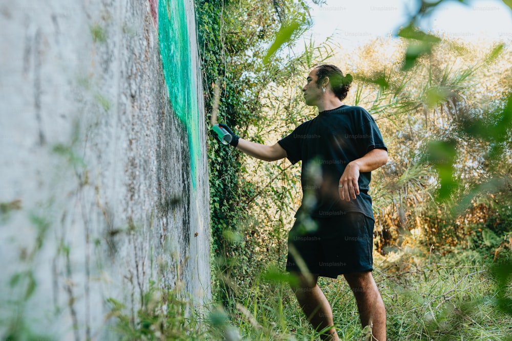 a man is painting a wall with green tape