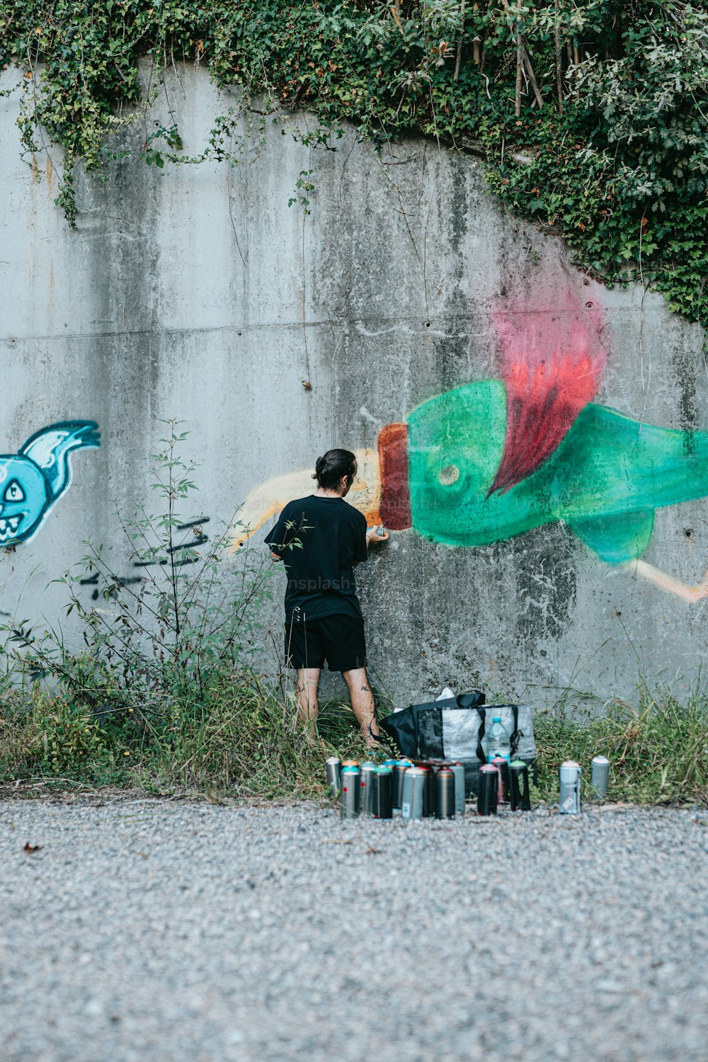 a man painting a fish on a wall