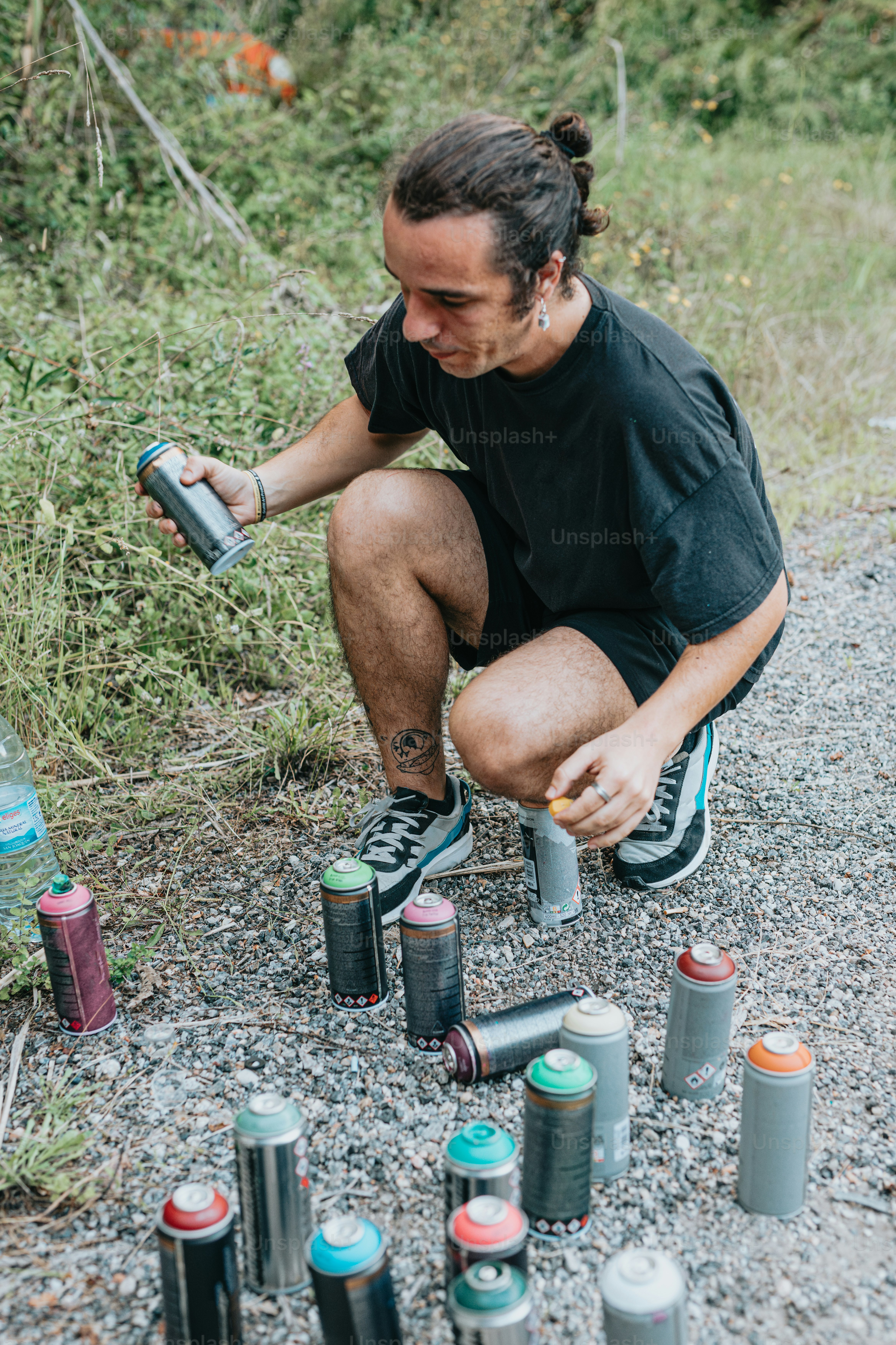 a man kneeling down next to a bunch of cans