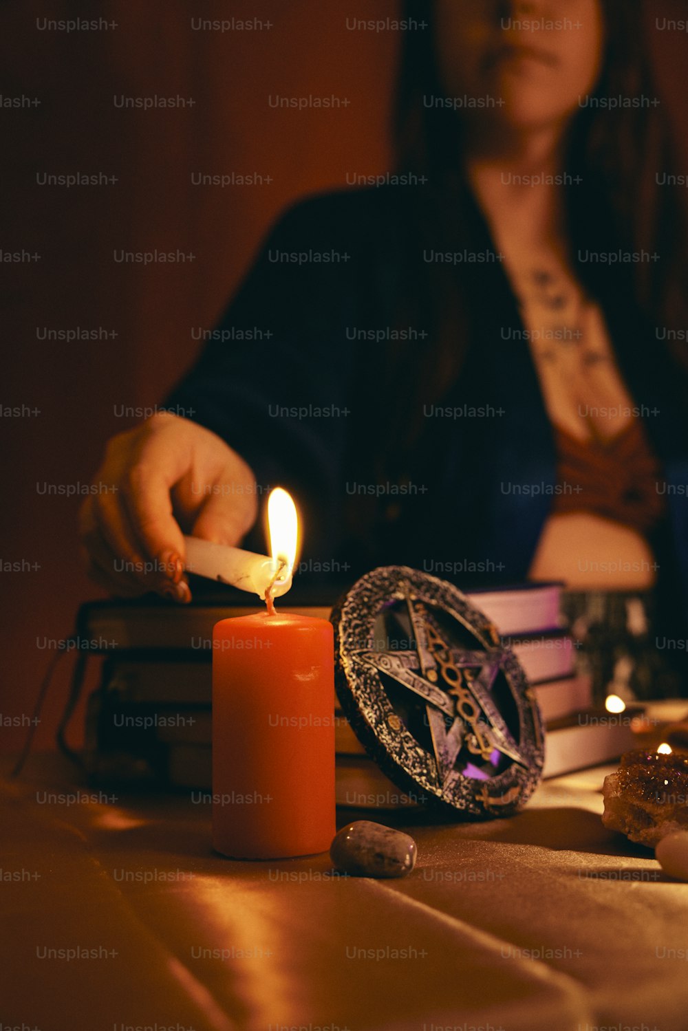 uma mulher sentada em uma mesa com uma vela acesa