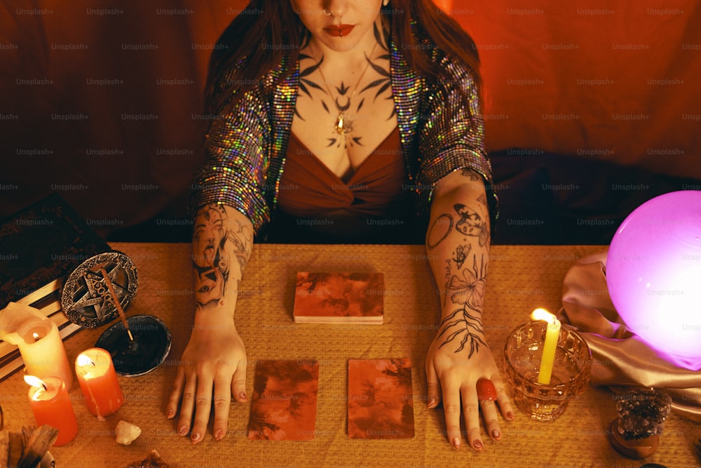 uma mulher com tatuagens sentada em uma mesa