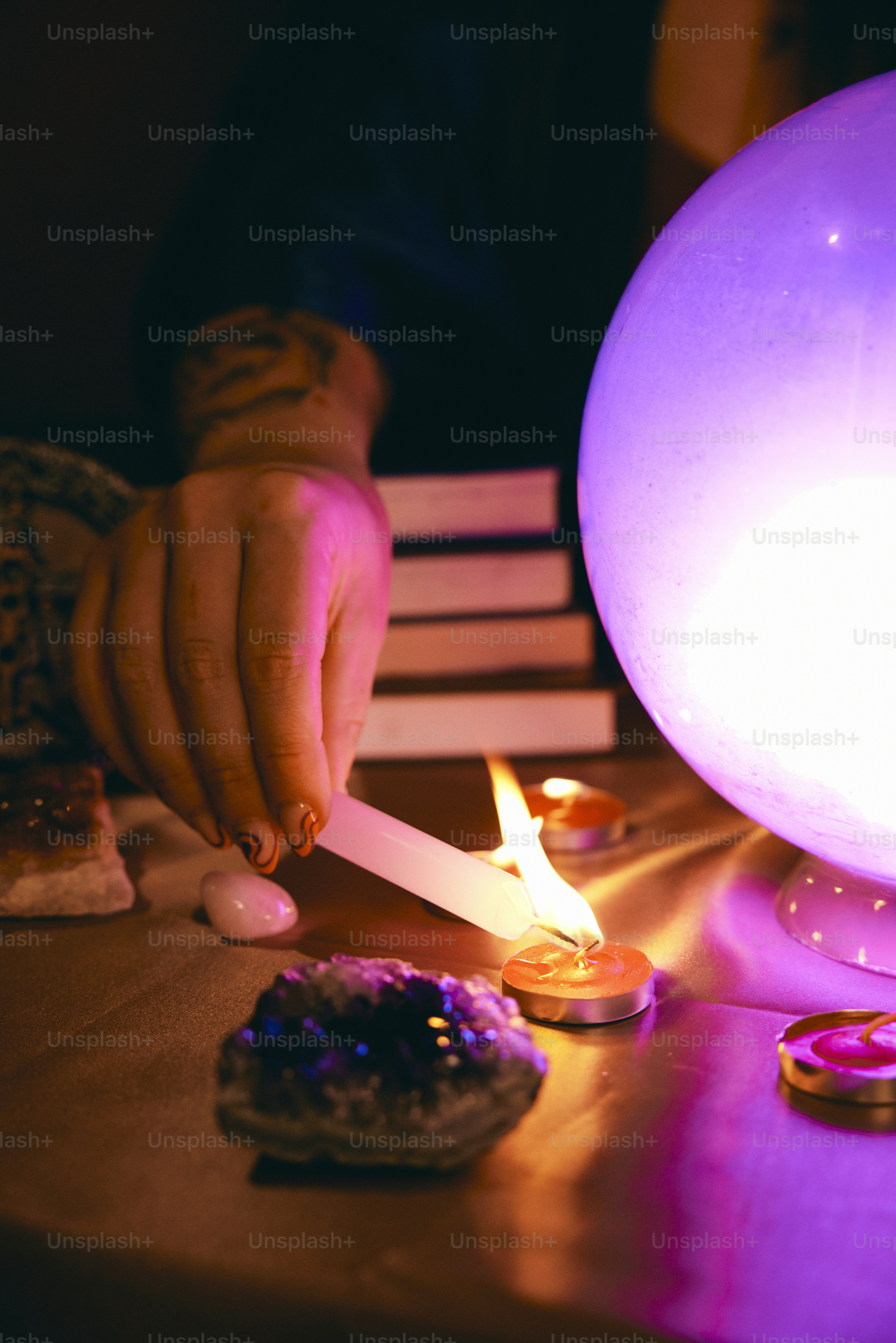 A person lighting a candle on a table photo Mystic Image on Unsplash