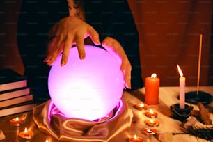 a person touching a glowing ball on a table