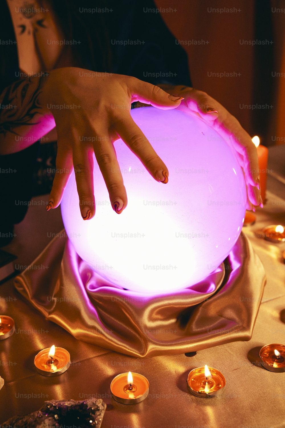 una persona tocando una bola brillante sobre una mesa