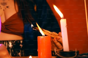 eine Person, die eine Kerze mit einem Stock anzündet