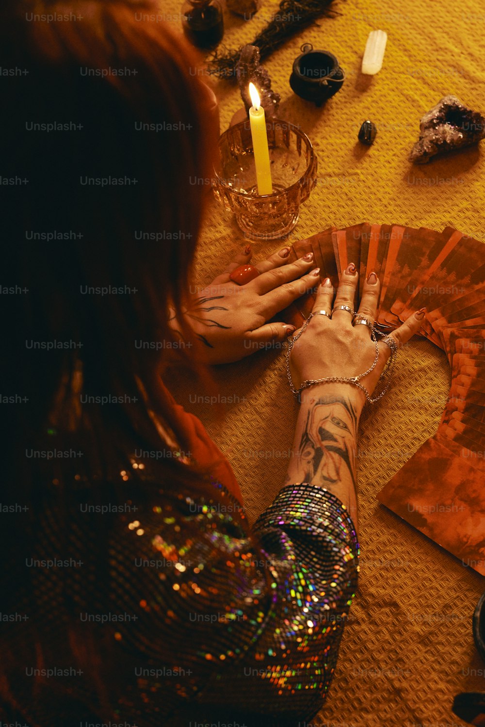 a woman sitting on the floor with her hands on a fan