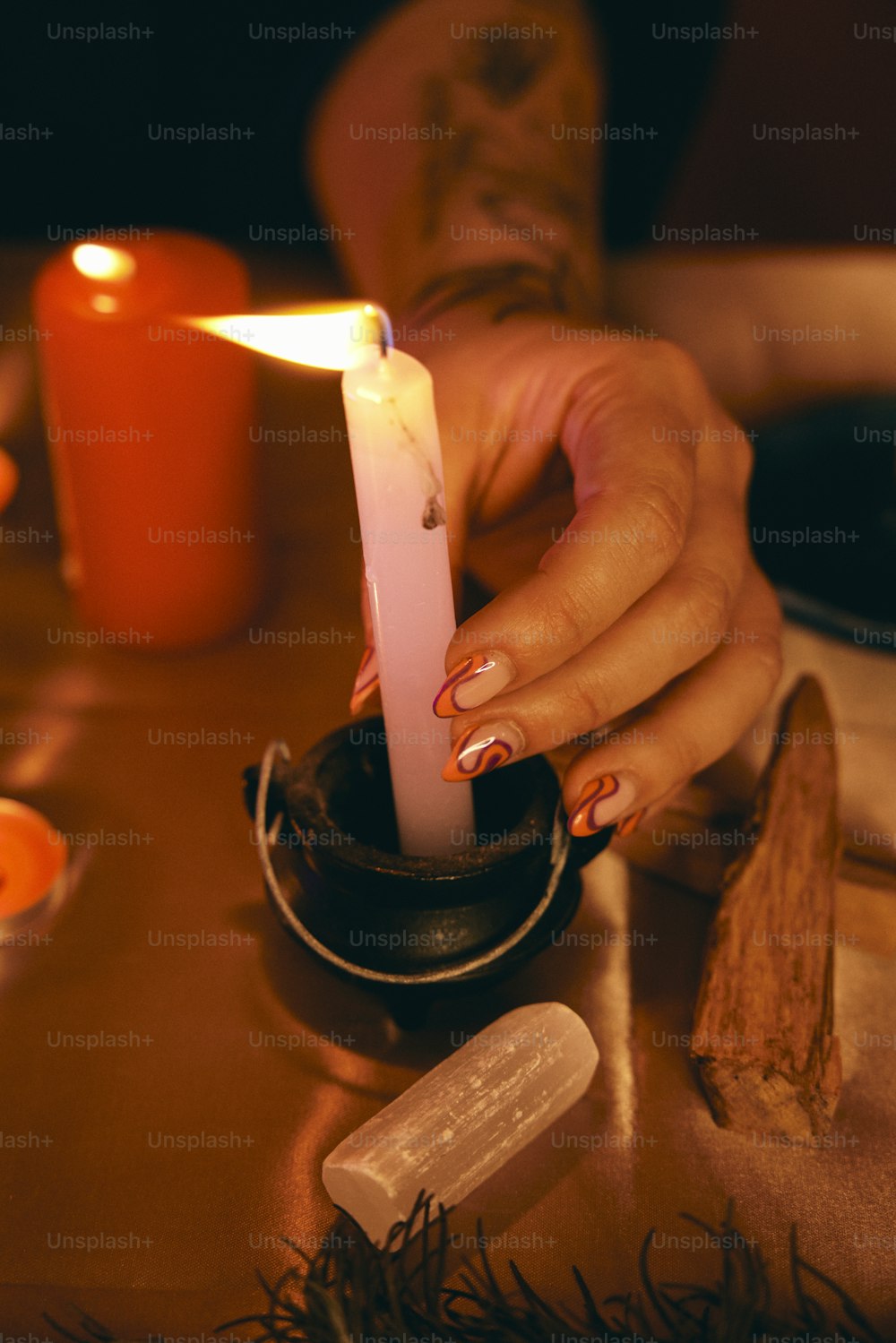 a woman holding a lit candle on top of a table
