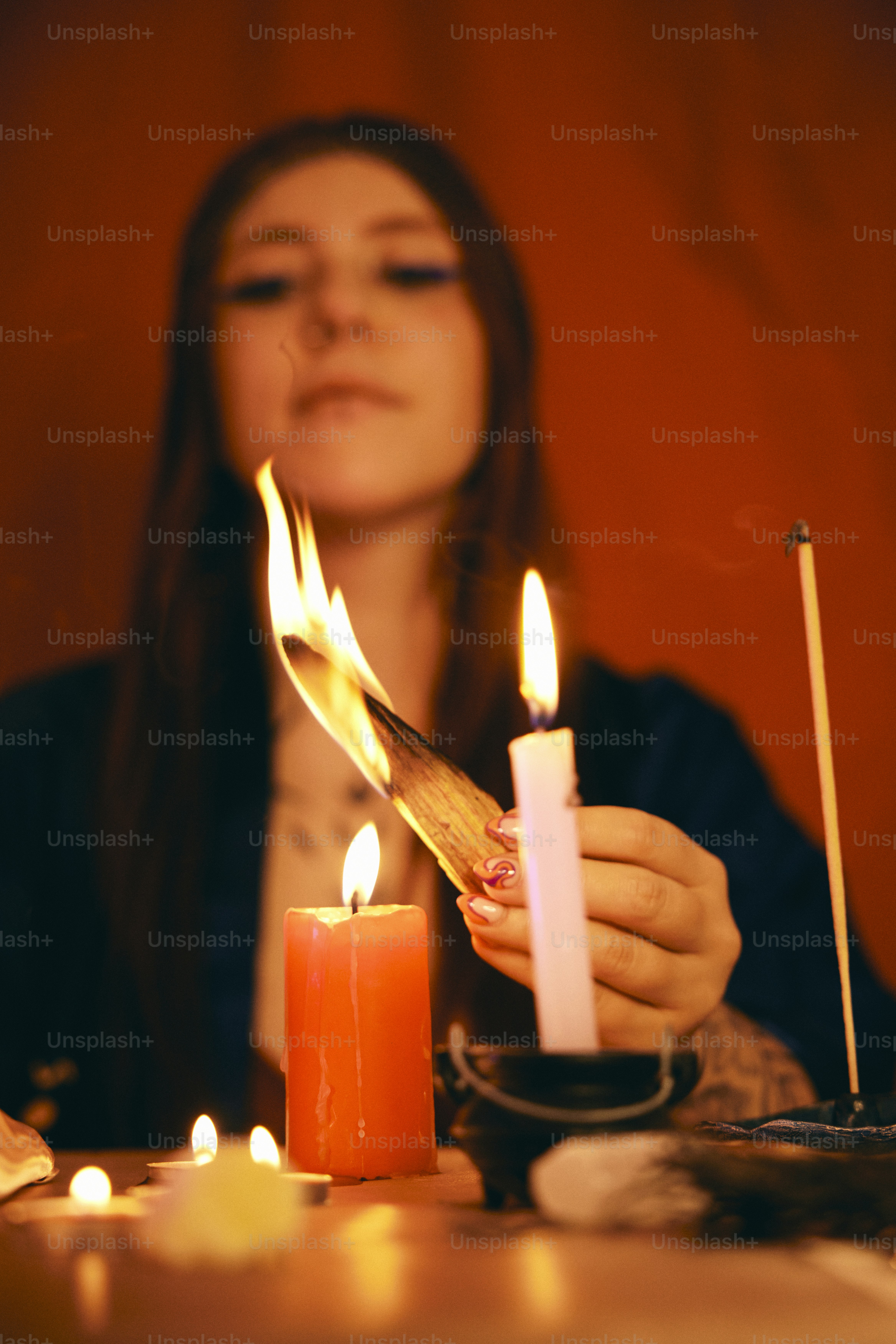 A woman lighting a candle on a table photo Tarot Image on Unsplash