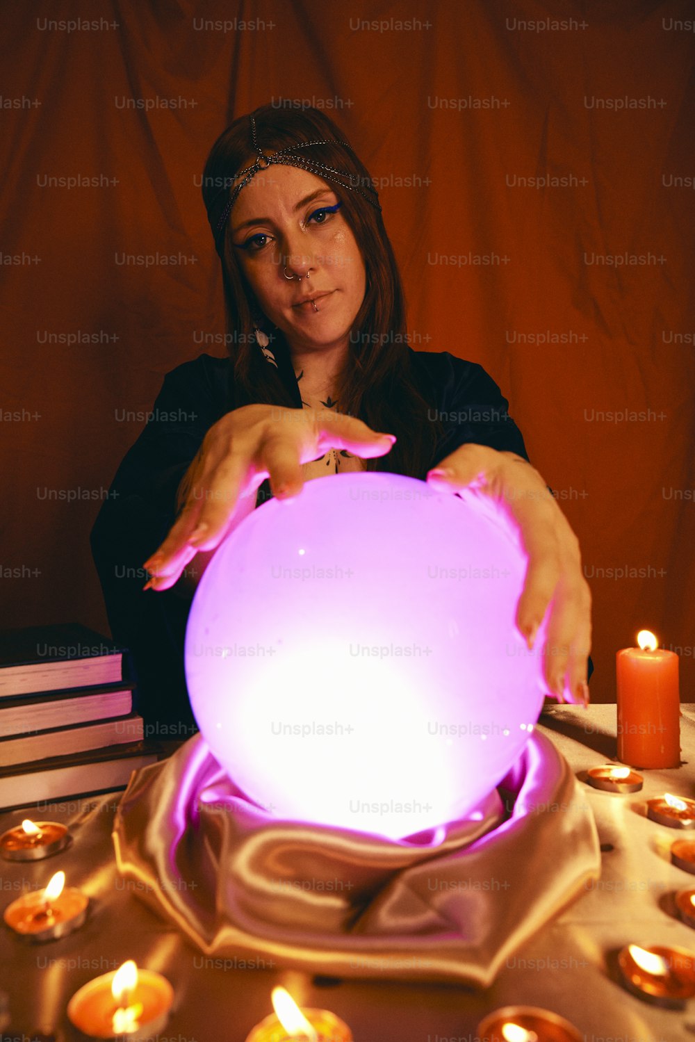 a woman sitting at a table with a glowing ball