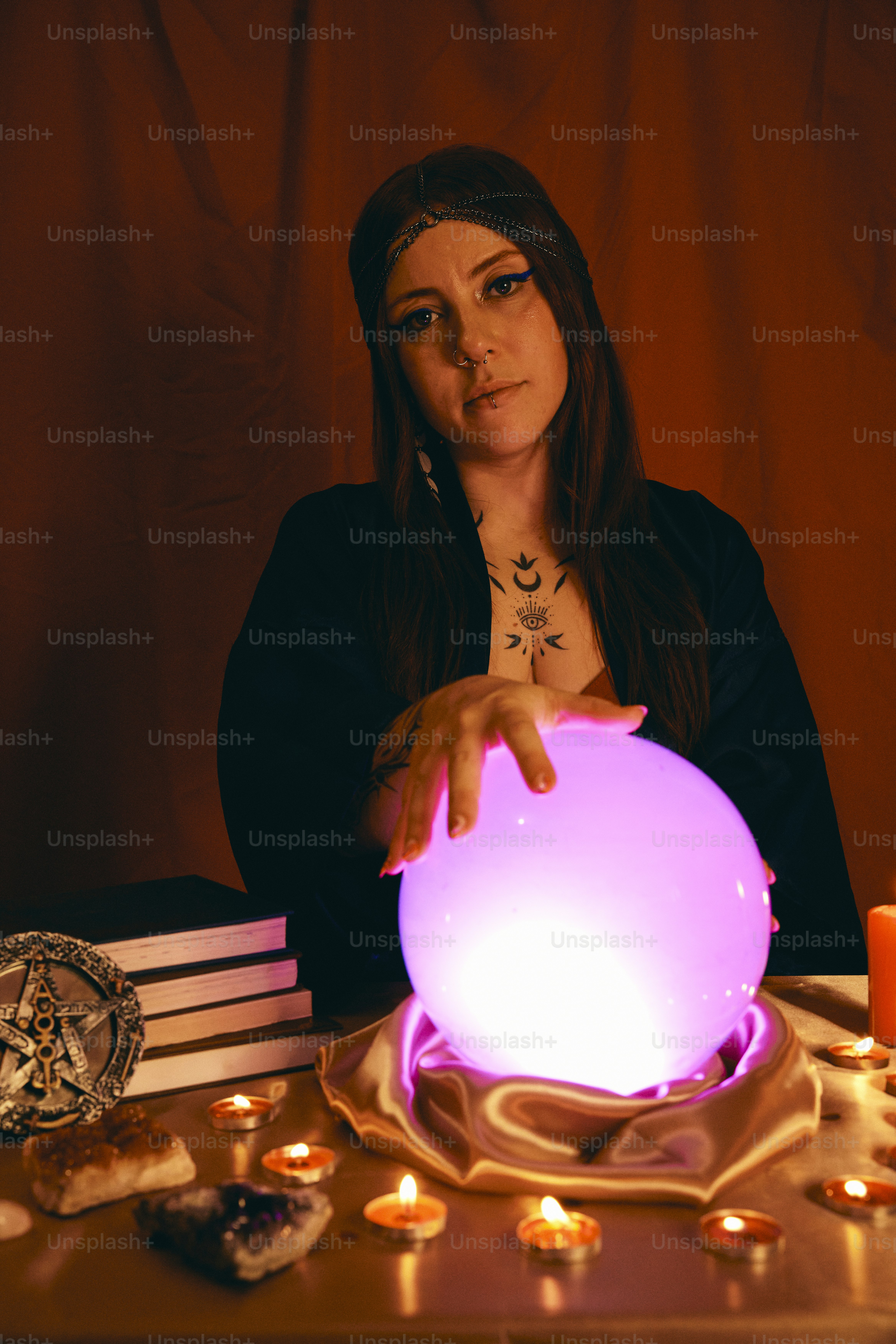 una donna seduta a un tavolo con una palla incandescente