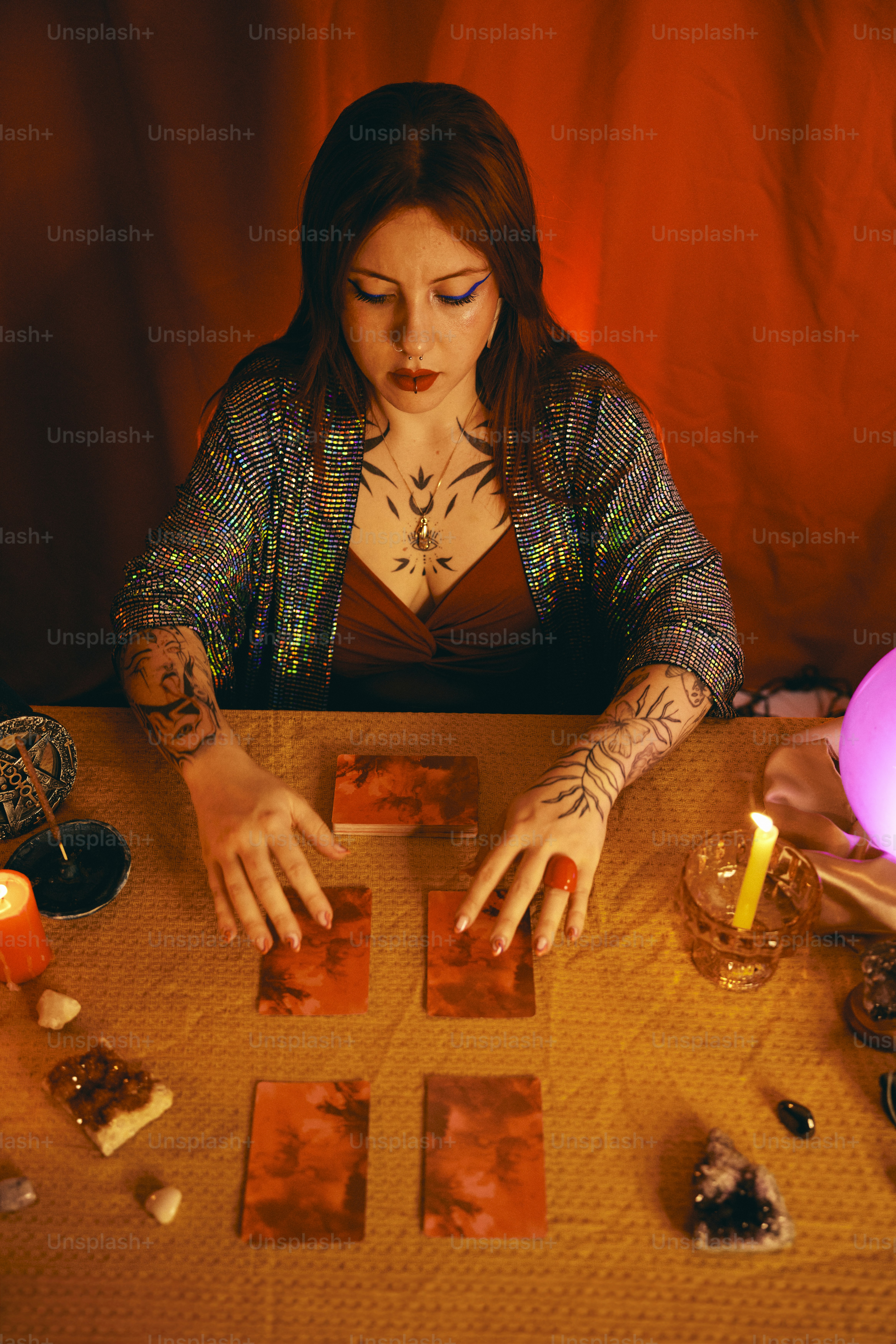 a woman sitting at a table with cards and candles