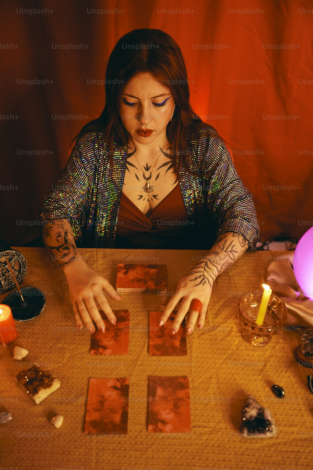 a woman sitting at a table with cards and candles