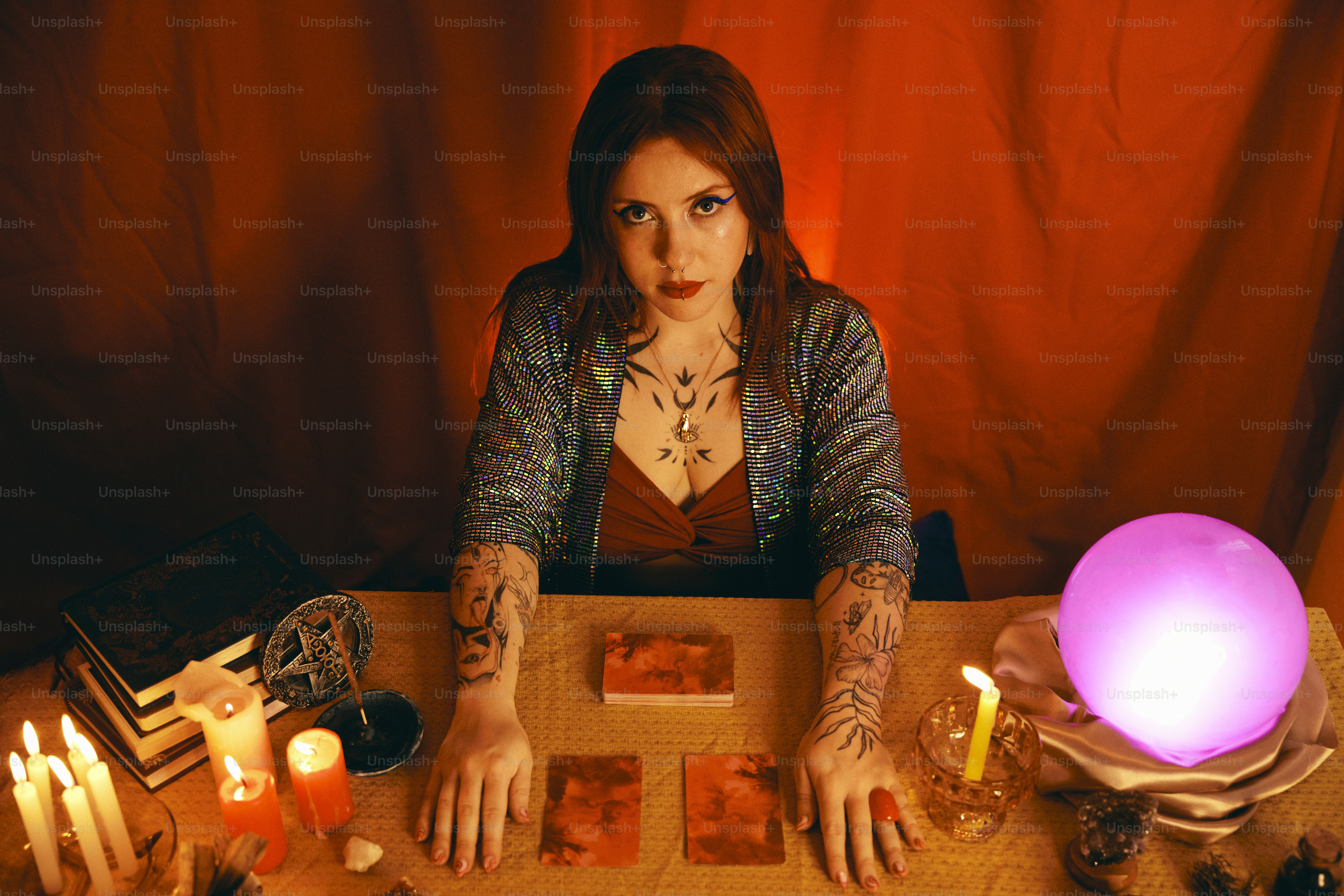 a woman sitting at a table surrounded by candles