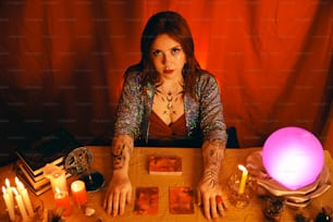 a woman sitting at a table surrounded by candles