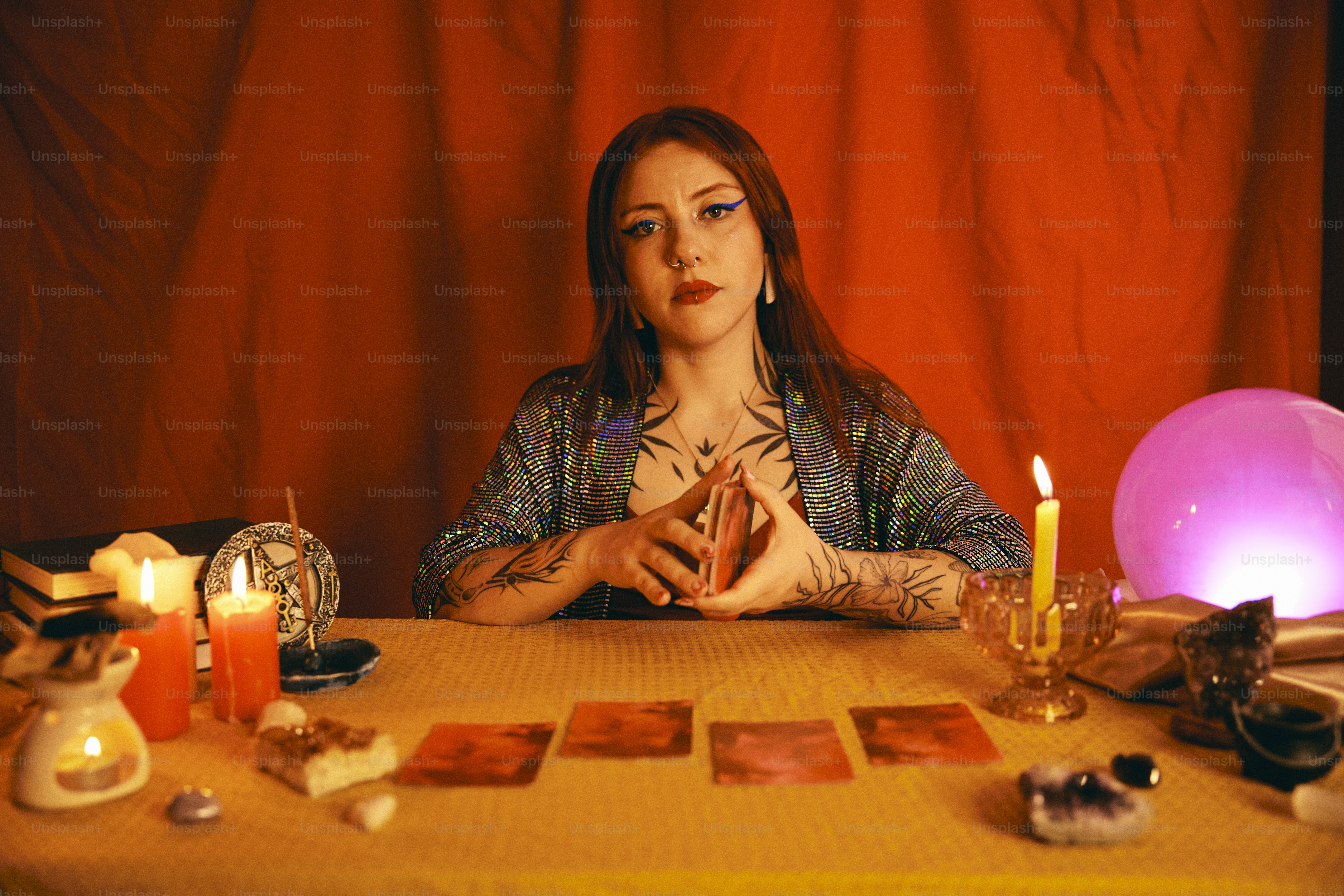 uma mulher sentada em uma mesa cercada por velas