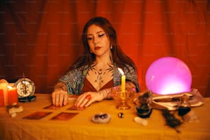 Una mujer sentada en una mesa con una vela encendida